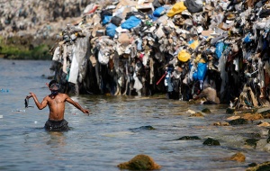A scavenger sifts through garbage from a rubbish dump on the Sidon seafront in south Lebanon